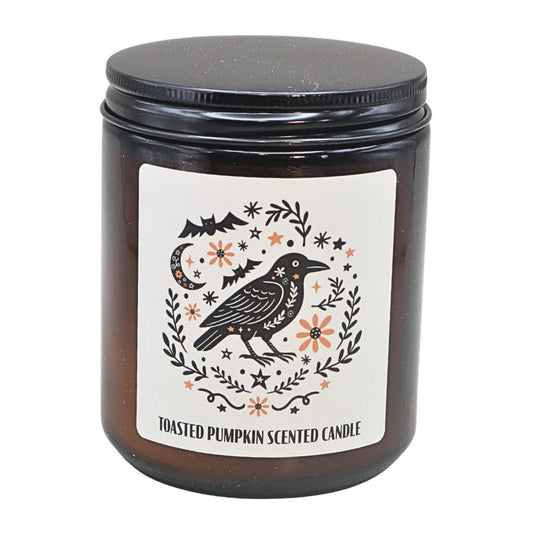 amber coloured jar with a white label with black and orange raven and floral design.
