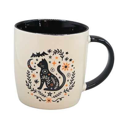 cream cup with black handle with an image of a black cat and black and orange floral design on a white background