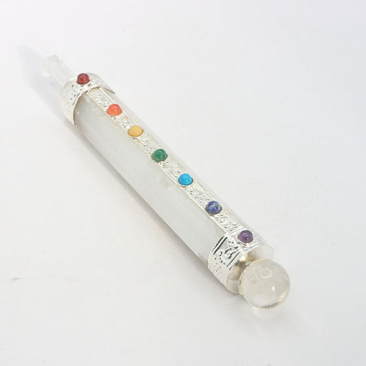 selenite crystal wand with chakra coloured stones on a white background