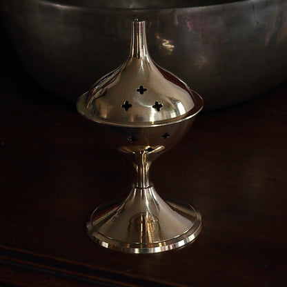 Brass incense burner on a dark background