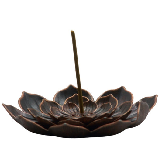 japanese incense stick in the centre of bronze lotus flower shaped incense holder