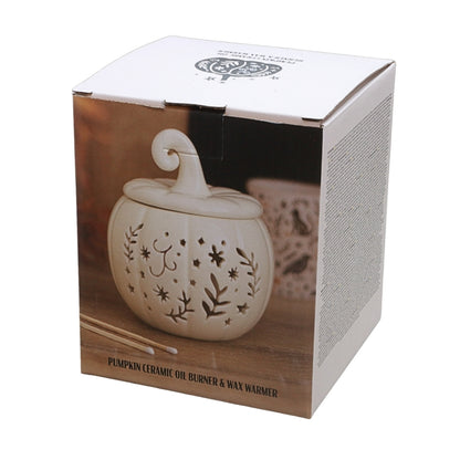A boxed ceramic oil burner and wax warmer shaped like a small pumpkin, shown in its retail packaging on a white background.