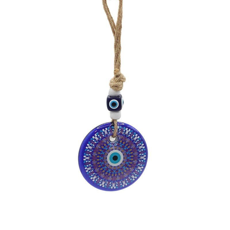 wall hanging with a blue evil eye pendant on a white background
