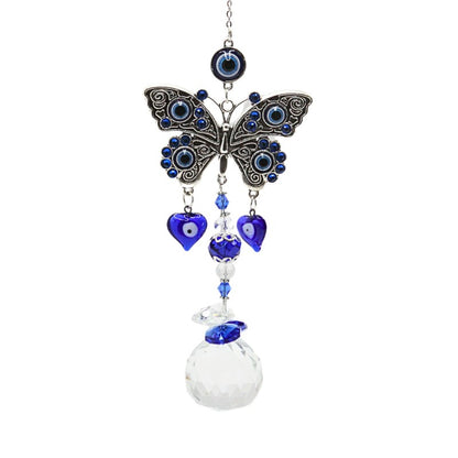 silver coloured metal butterfly hanging from a silver coloured chain and crystal teardrop suncatcher beneath- The butterfly has blue, black and white eye designs in the wings and the suncatcher has blue and clear beads above