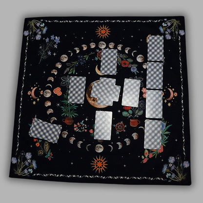 celtic cross tarot spread on a floral tarot cloth showing the moon phases