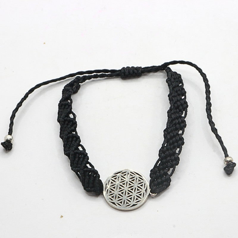 Black braided bracelet with a silver pendant on a white background