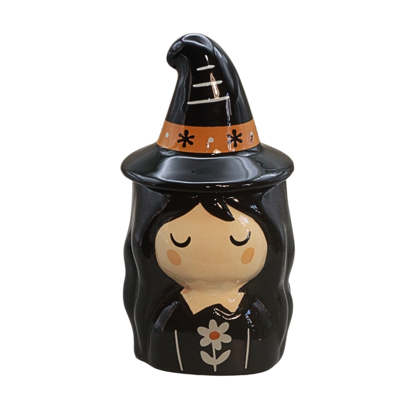 A glossy black ceramic witch figurine with a pointed hat, orange band, and a stylized face with closed eyes, set against a plain white background.