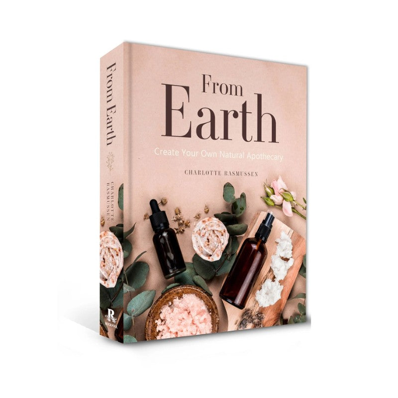 Book titled 'From Earth' with natural products and flowers on a beige background