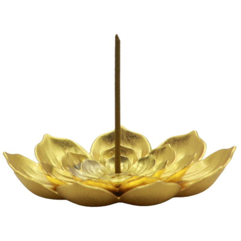 japanese incense stick in the centre of gold lotus flower shaped incense holder