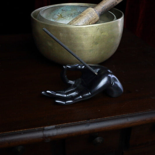 Hand Incense Holder in front of brass singing bowls