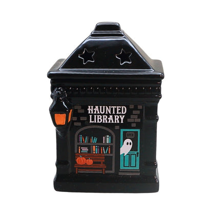 ceramic oil burner in the shape of a building with ghost and book images on, titled "haunted library"