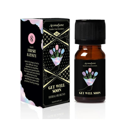 A small amber glass bottle with a black cap stands beside its matching retail box. The packaging and label read Aromafume and Get Well Soon Herbal Oil Blend, with a black background and pastel tulip illustration.