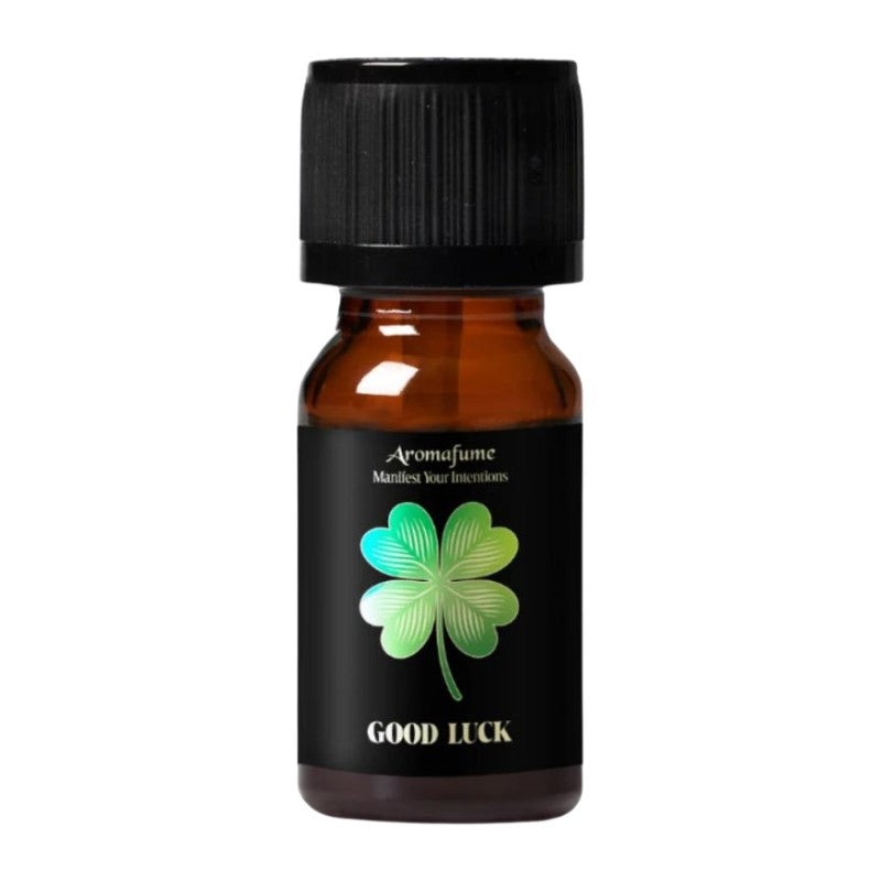 A small amber glass bottle with a black ribbed cap and a black label. The label features a green and blue four-leaf clover graphic with the text 'Aromafume', 'Marine Salt Distillation', and 'GOOD LUCK' in white.