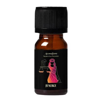 A small amber glass bottle with a black ribbed cap and a black label. The label features a stylized figure in a pink-to-orange gradient and the words 'Aromafume Manifest Your Intentions' and 'JUSTICE'.