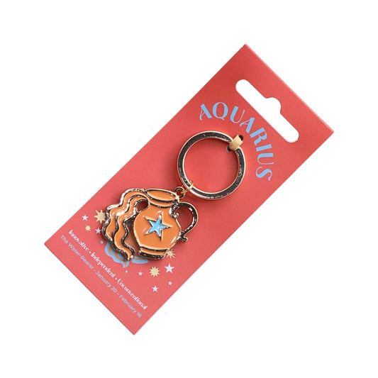 An Aquarius-themed enamel keychain charm on its red cardboard hanger card. The charm features a gold-plated metal ring and body with an orange and blue enamel design depicting a water pitcher and a star.