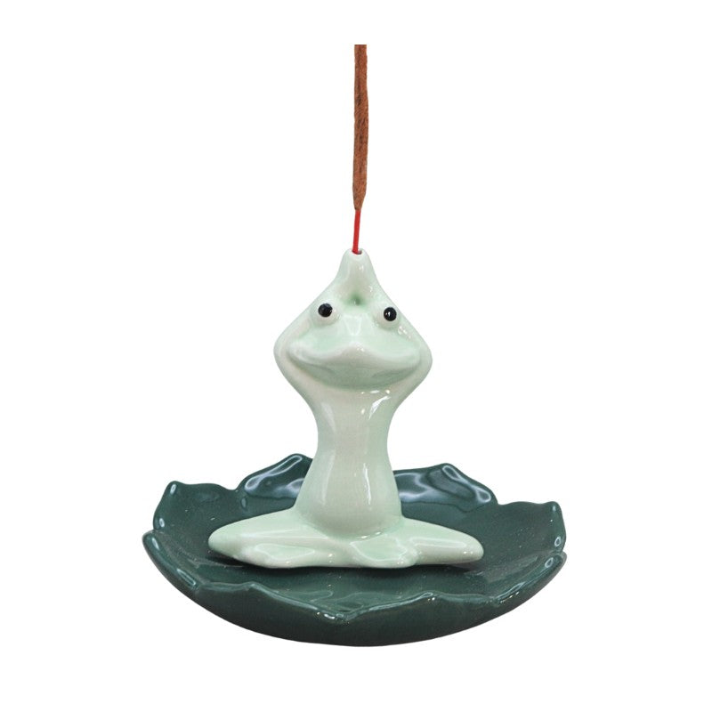 green frog sitting cross legged on lil pad holding incense stick above head