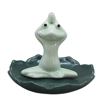 green frog sitting cross legged on lily pad holding hands above head