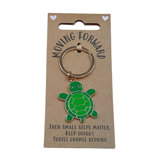 Green turtle enamel keyring on a 'Moving Forward' card with motivational text.