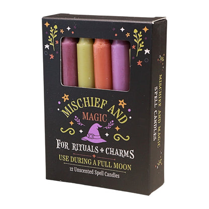A box of 'Mischief and Magic' unscented spell candles, featuring four colorful wax candles visible through a clear window on a black packaging box with green and white text.