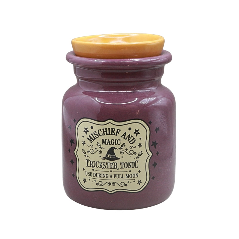 A purple ceramic oil burner  with a yellow bowl, featuring a vintage-style label that reads 'Mischief and Magic Trickster Tonic'.