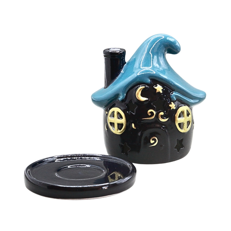 A small dark blue ceramic witch house candle holder with a blue roof and gold decorative details, shown with its matching base on a white background.
