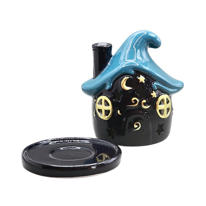 A small dark blue ceramic witch house candle holder with a blue roof and gold decorative details, shown with its matching base on a white background.