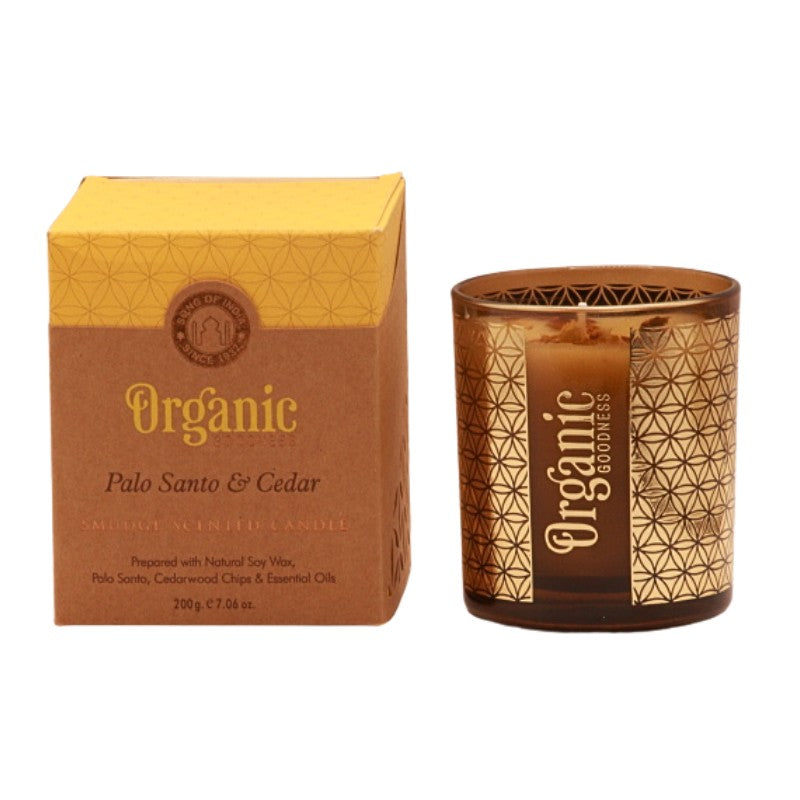 organic goodness candle box next to soy candle in a brown and gold votive candle jar