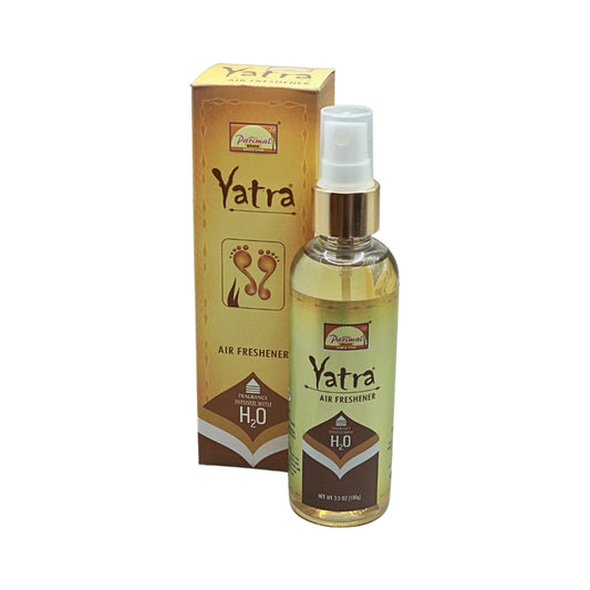Parimal Yatra air freshener spray bottle with a gold collar and clear cap, displayed in front of its gold box.
