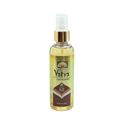 Clear Parimal Yatra air freshener bottle containing pale yellow liquid, with a gold collar and clear spray cap.