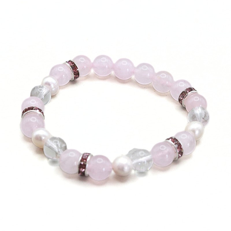 A beaded stretch bracelet featuring light pink rose quartz beads, white faux pearl beads, and clear faceted crystal beads, separated by small metallic spacer rings.