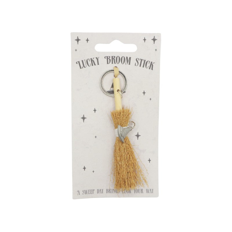 tiny broomstick, with a white string and a witches hat charm attached to it on a silver keyring