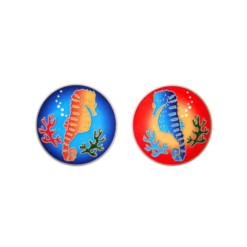 Two round stickers featuring a seahorse and coral reef designs, one with a blue background and one with a red background, shown side by side on a white background.