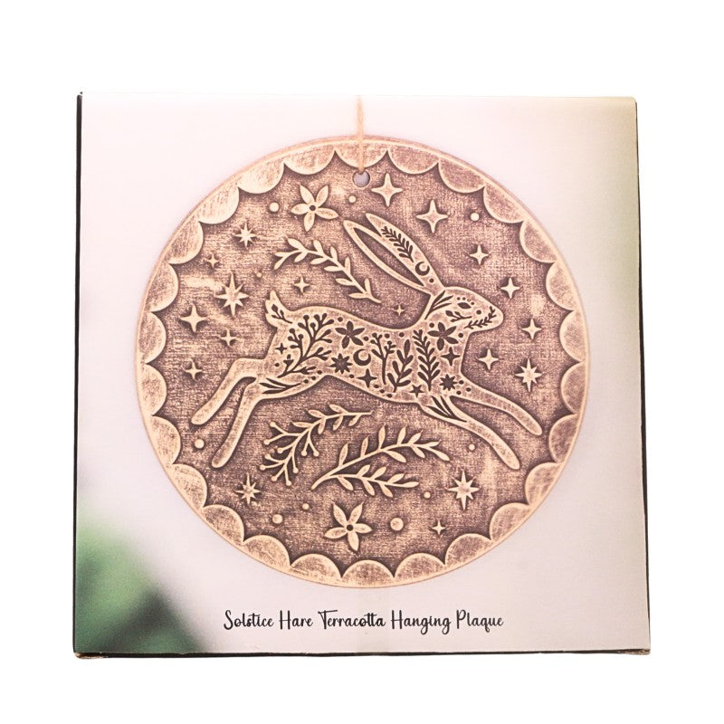 cardboard packaging showing a round gold plaque with a leaping hare and floral design