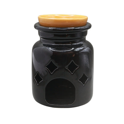 A glossy black ceramic oil warmer with diamond-shaped cutouts and a warm amber-colored lid, shown against a plain white background.