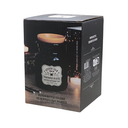Black product packaging box for a spider silk venomous elixir potion bottle ceramic oil burner and wax warmer, featuring product imagery and text on a white background.