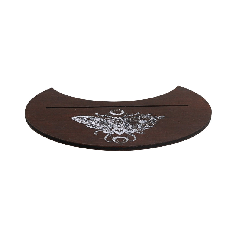 A dark brown wooden plaque with a curved top edge, featuring a white engraved moth design with a crescent moon and a horizontal slot across the center, shown on a plain white background.