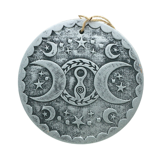 silver coloured terracotta wall plaque with image of a spiral goddess in a circle ith two crescent moons at either side
