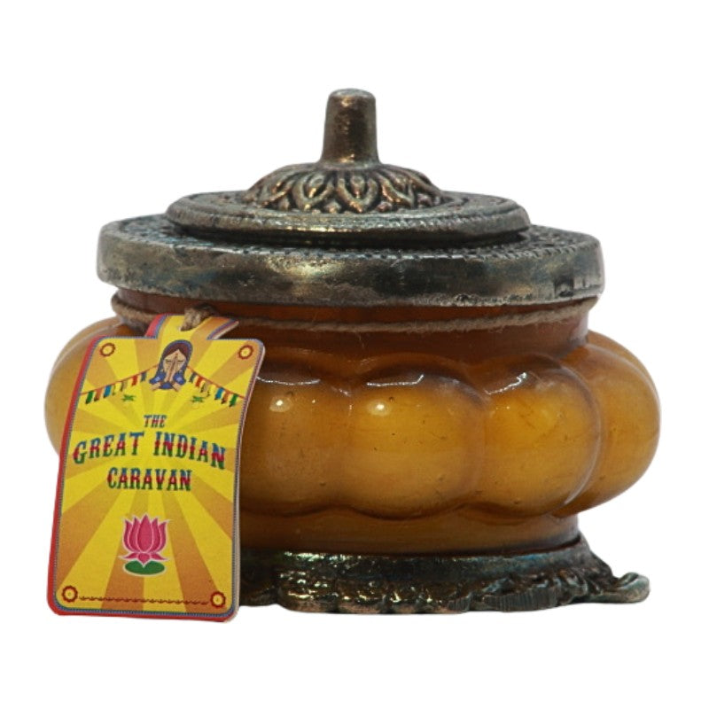 yellow ornate glass candle jar with a metal lid