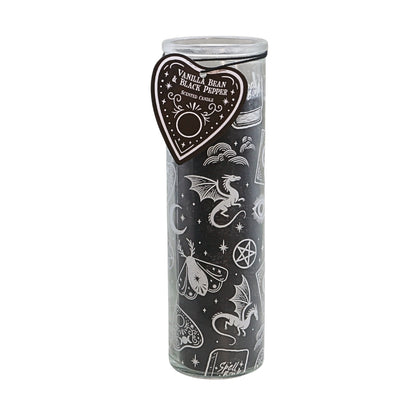 A tall glass jar candle with a black wax fill and white occult-themed illustrations, featuring a heart-shaped paper tag that reads 'Vanilla Bean Black Pepper' and 'Soul Fire'.