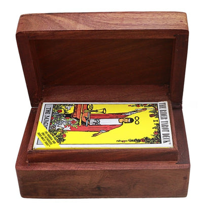 A wooden tarot card deck box shown open, containing a tarot card with a yellow background and red illustration. The box is made of medium brown wood and photographed on a plain white background.