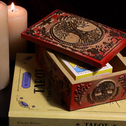 tree of life Tarot Card Storage Box with a pack of pocket sized rider waite tarot cards in front of beeswax candles on a tarot book