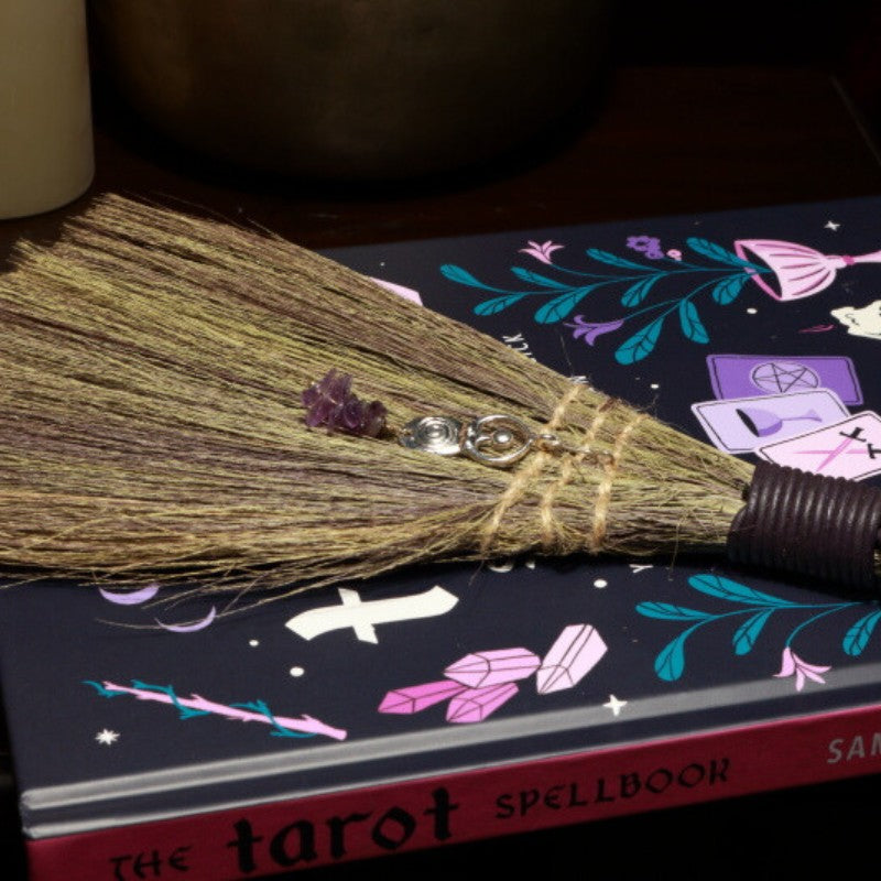 Witches Broom with Amethyst chips and Goddess charm on a tarot spell book