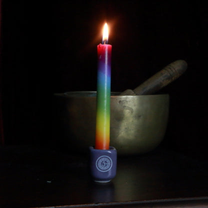 chakra candle in crown chakra spell candle holder in front of singing bowl