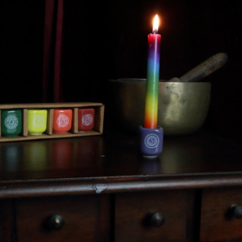 chakra candle in crown chakra spell candle holder in front of singing bowl and candle holders