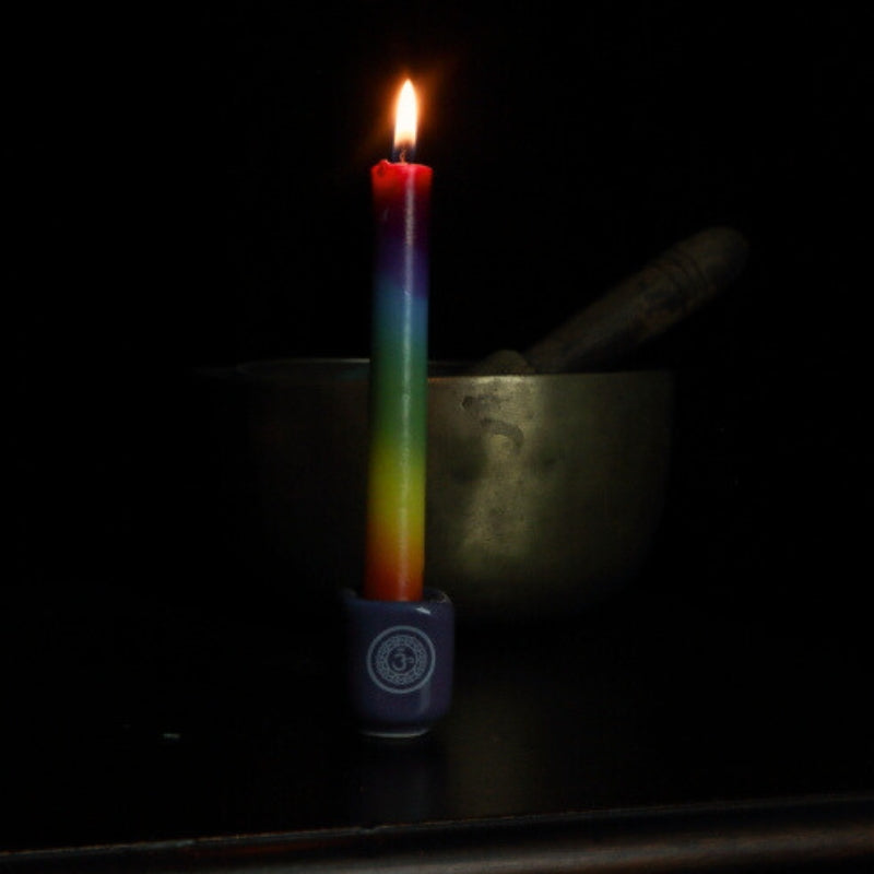 chakra candle in throat chakra spell candle holder in front of singing bowl