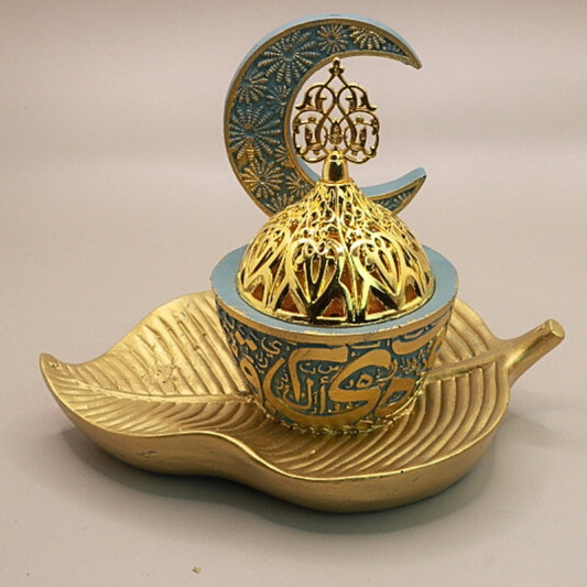blue and gold incense burner in the shape of a crescent moon on a gold leaf