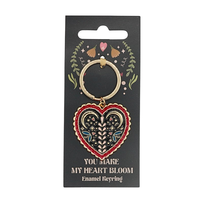 Heart-shaped enamel keyring on a black card with decorative elements
