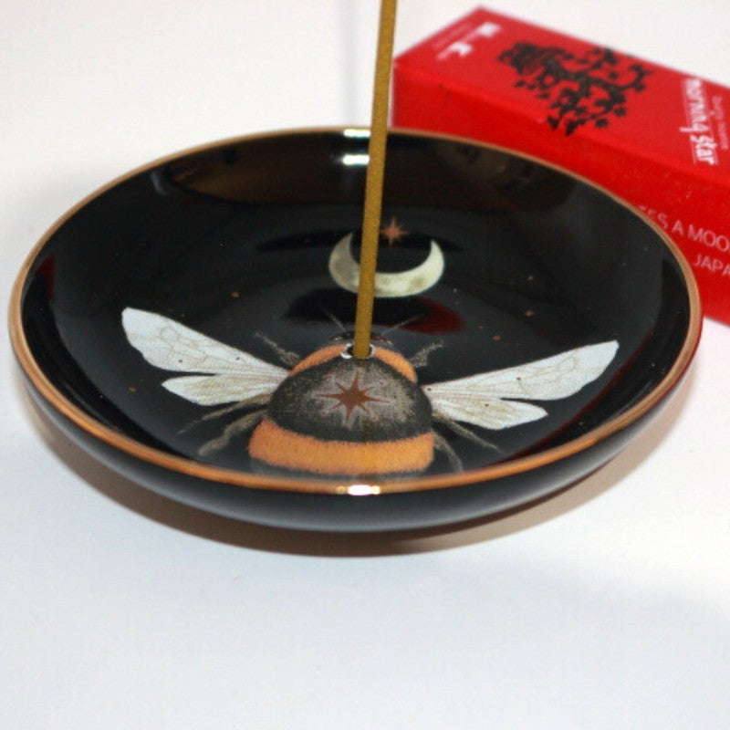 bee design incense dish in front of a box of japanese incense