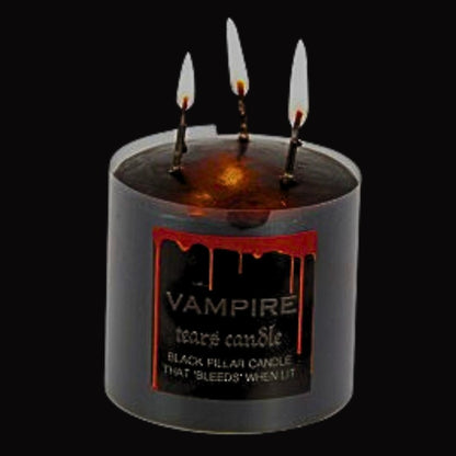 lit  black pillar candle that bleeds red wax when lit