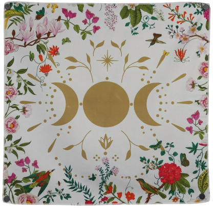 white tarot cloth with floral borders embellished with a gold moon in between two gold crescent moons